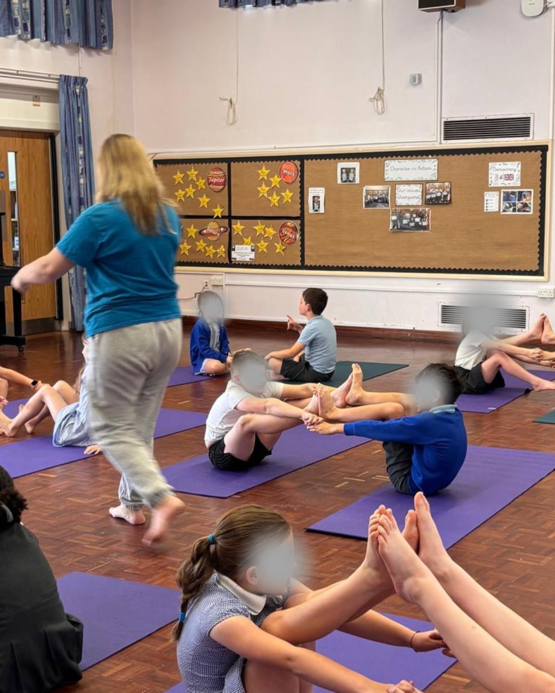 Ramsey Manor Boat Yoga Participants doing yoga boat pose in a school hall