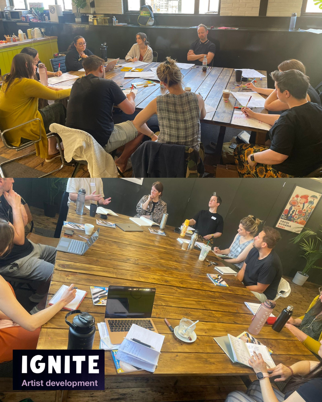 People sitting a ound a large table in a workshop discussion